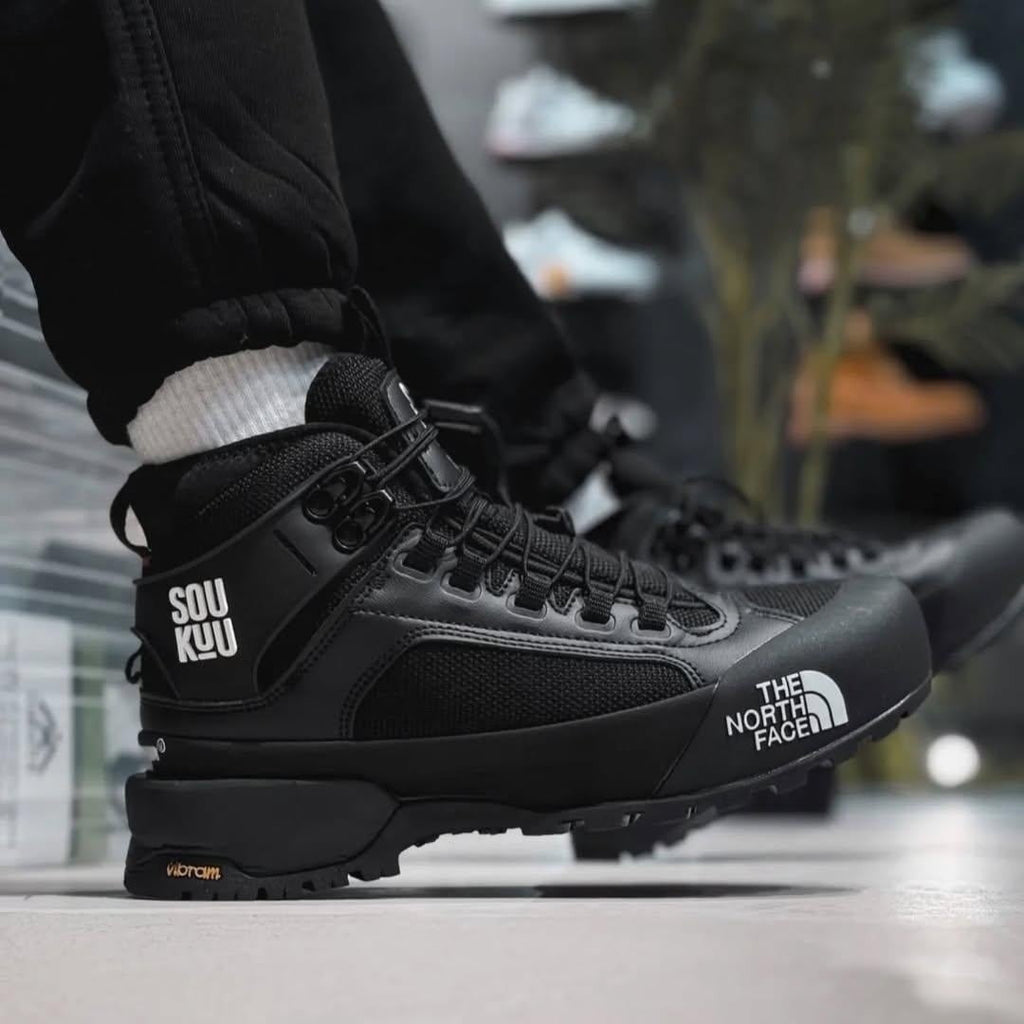 The North Face Glenclyffe Boot Undercover SOUKUU noires, reconnaissables à leur logo imposant sur le côté