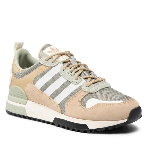 Le modèle présenté dans l'image est la adidas ZX 700 HD dans son coloris bleu marine classique avec les trois bandes blanches caractéristiques de la marque adidas.