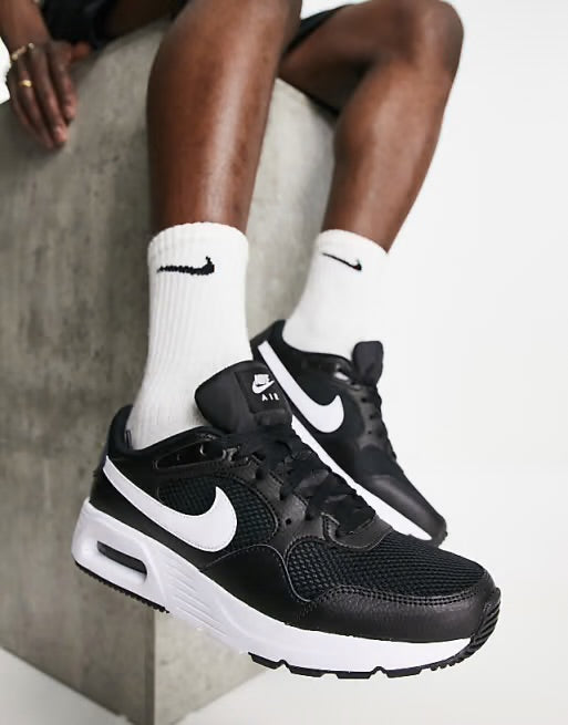 Nike Air Max SC, caractérisée par sa tige en maille noire et son logo Swoosh blanc