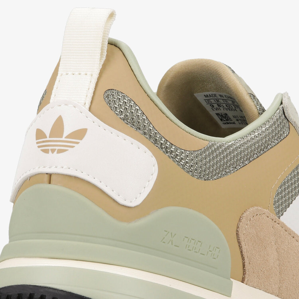 Le modèle présenté dans l'image est la adidas ZX 700 HD dans son coloris bleu marine classique avec les trois bandes blanches caractéristiques de la marque adidas.