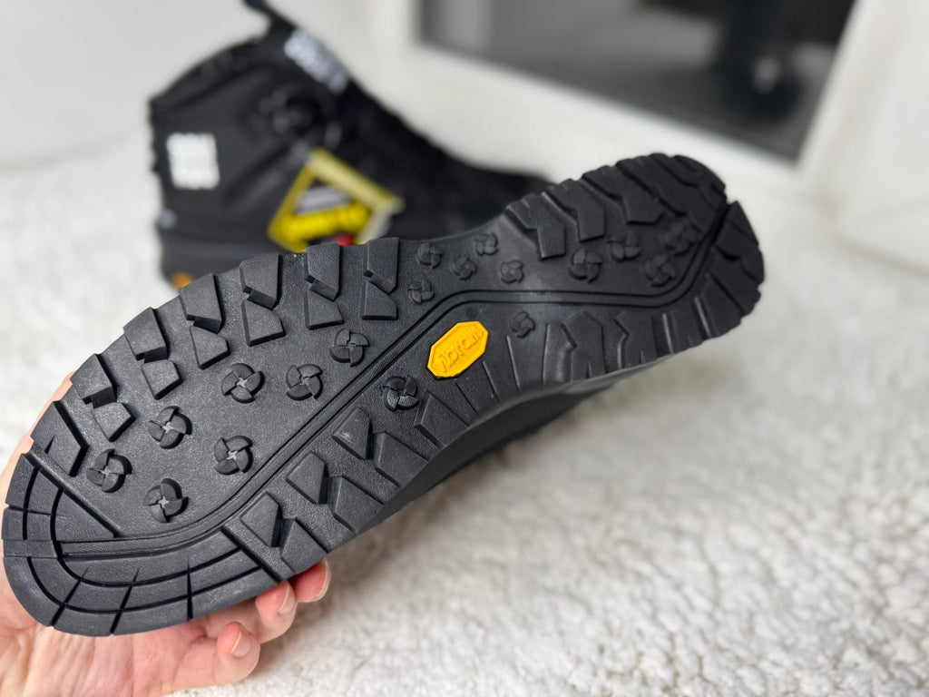 The North Face Glenclyffe Boot Undercover SOUKUU noires, reconnaissables à leur logo imposant sur le côté