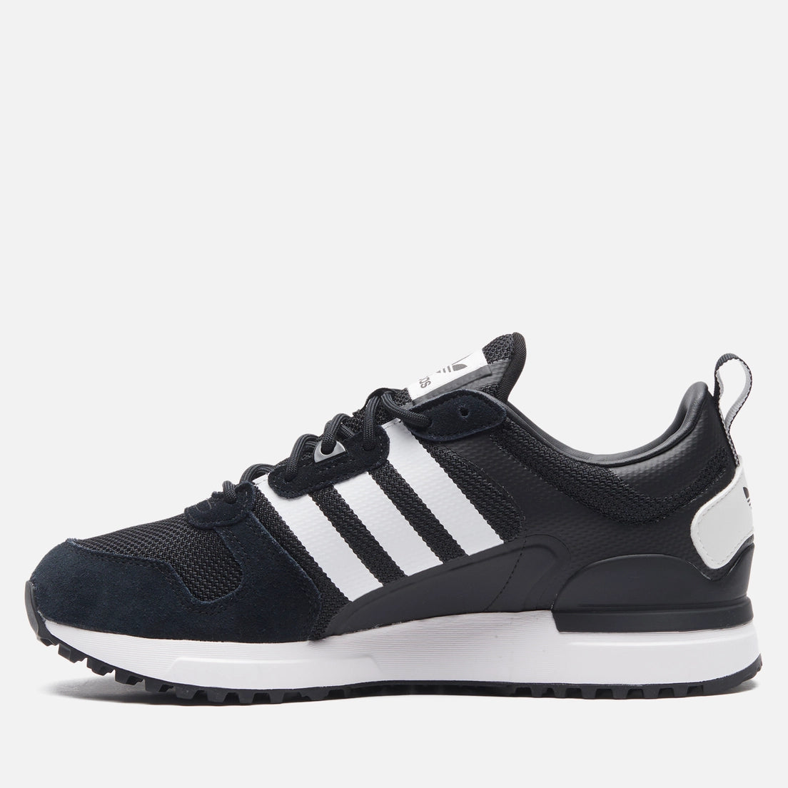 Le modèle présenté dans l'image est la adidas ZX 700 HD dans son coloris bleu marine classique avec les trois bandes blanches caractéristiques de la marque adidas.