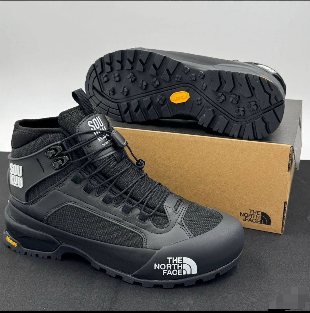 The North Face Glenclyffe Boot Undercover SOUKUU noires, reconnaissables à leur logo imposant sur le côté