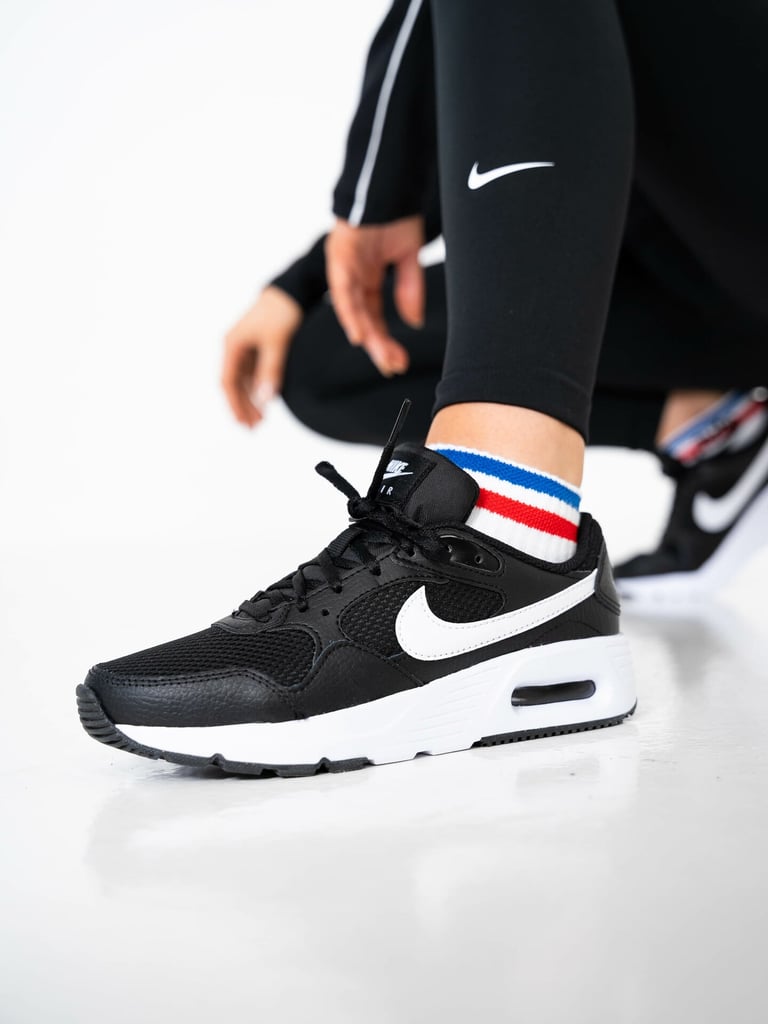 Nike Air Max SC, caractérisée par sa tige en maille noire et son logo Swoosh blanc