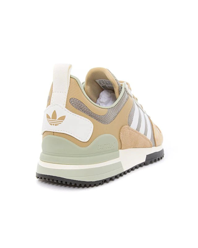 Le modèle présenté dans l'image est la adidas ZX 700 HD dans son coloris bleu marine classique avec les trois bandes blanches caractéristiques de la marque adidas.