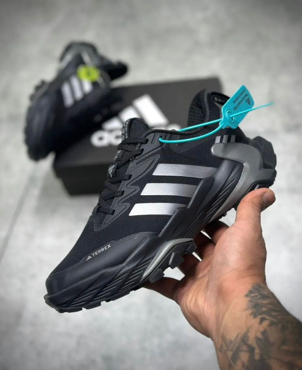Adidas Terrex noires arborent trois bandes argentées distinctives sur les côtés.Marque/Modèle : Adidas Terrex